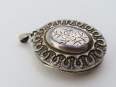 A Victorian silver oval locket with raised floral