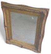 A large gilt framed mirror, with curved sides and