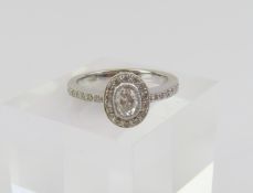 An 18ct white gold diamond ring, the oval mixed cu
