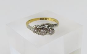 A diamond three stone twist ring with engraved pat