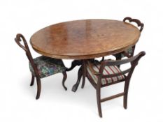 A walnut tilt top table with three antique chairs,