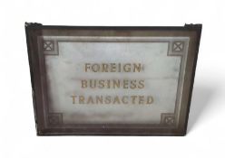 A glass sign with gilt text