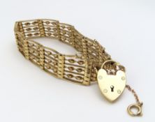 A 9ct gold seven bar gate bracelet with a heart sh