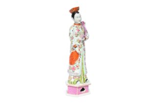 A tall Chinese famille rose nodding head figure, 20th C.