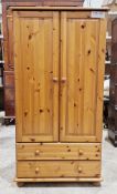 Modern small pine wardrobe with two doors opening to a hanging space and two long drawers below,