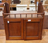 Edwardian mahogany hanging wall cupboard with spindle top rail and two panel doors opening to a