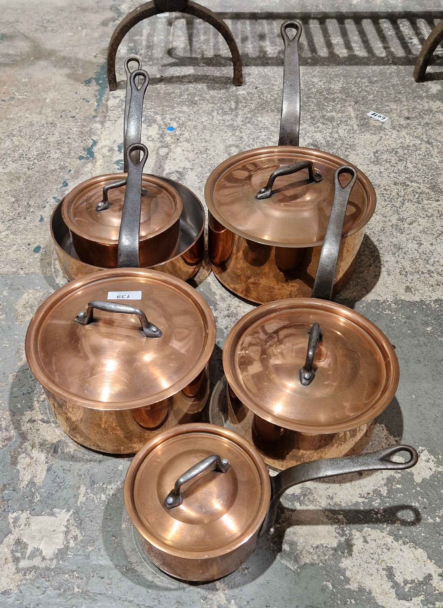 Assembled French graduated set of five copper saucepans and lids and frying pan, variously stamped