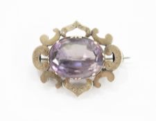 Victorian gold-coloured metal and purple stone brooch, the oval amethyst-coloured stone within C-