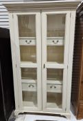 Modern white finish glazed cabinet, the tall glazed doors opening to three shelves and four small