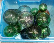 Seventeen glass fishing floats of various sizes including green blue and orange, some a/f, largest