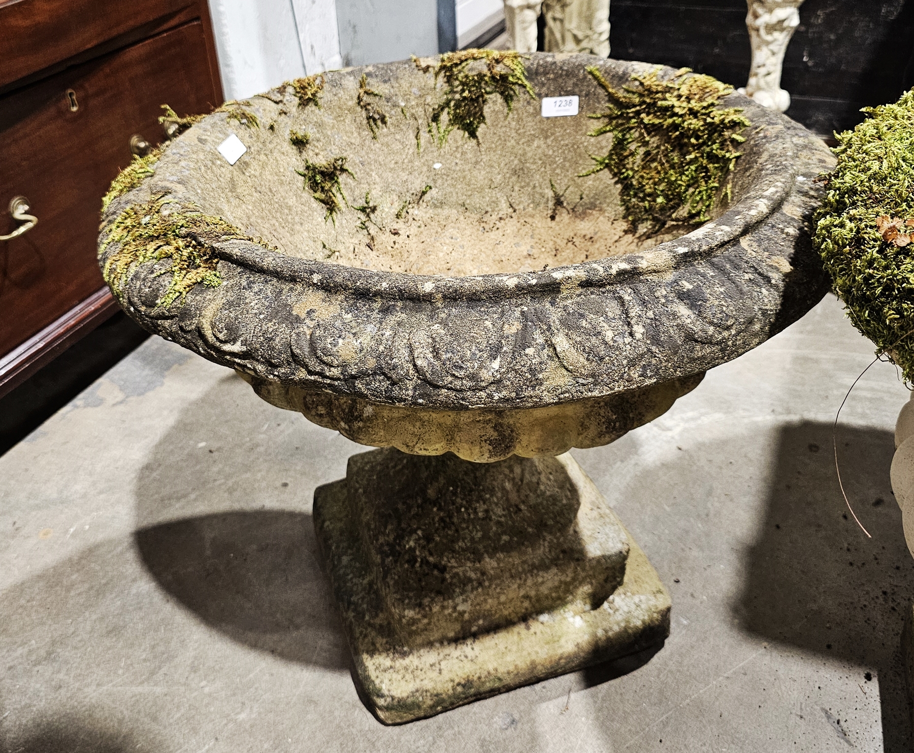 Pair of composite stone garden terrace urns of campana form, with moulded egg and dart rim, on a