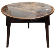 Antique oak cricket table, the circular plank top on a base with a deep frieze and three turned