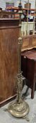 Brass aesthetic movement standard lamp, the column cast with scrolls and foliage, on a circular base