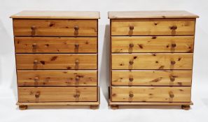 Pair of modern pine chests of five long drawers, each with turned knob handles, on bun feet, each