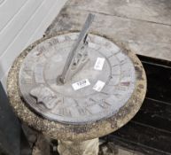 Lead garden sundial set on a composite stone circular plinth base moulded with vines, on a scrolling