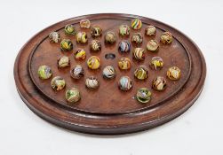 19th / early 20th century mahogany solitaire board on three bun feet, 30cm diameter with 32 German