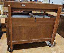 Mid-century teak storage trolley, with two sliding shelves opening to a storage compartment, on