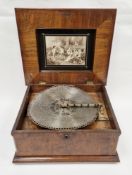 19th century German symphonion in figured walnut case, the hinged with floral inlaid panel, the