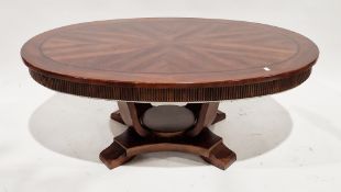 Modern mahogany veneered coffee table, the oval quarter-veneered top with carved fluted frieze, on