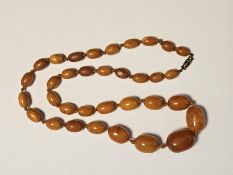 Butterscotch amber bead necklace comprising a single row of 34 graduated beads, approximately 60cm