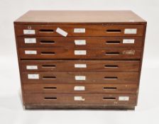 Mid-century teak plan chest comprising seven long drawers, each with two recessed handles, on a