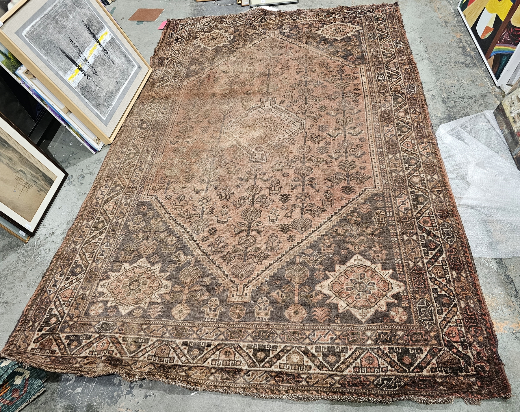 Eastern green ground carpet with central geometric medallion on floral and stylised animal pattern