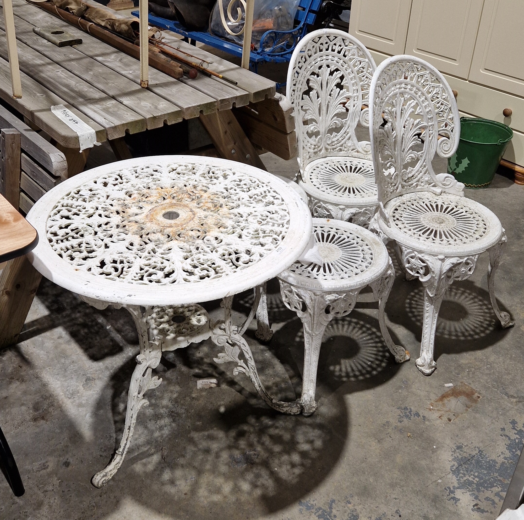 White painted metal garden table, two stools and two chairs featuring foliate design (5)