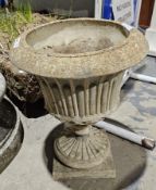Composite stone garden pedestal urn in the neo-classical style, the urn having a fluted body over an