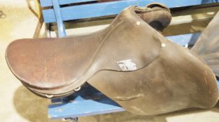 Three vintage brown leather saddles, associated tack, riding crops and other items
