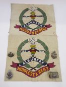 Three white metal Middlesex regiment cap badges, silver matchbox holder with Middlesex regiment