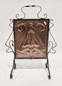 Art Nouveau firescreen, the central copper panel with repousse stylised flower decoration held