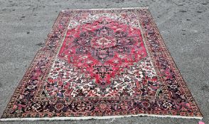 Large red ground carpet with central floral medallion, cream floral spandrels and multiple floral