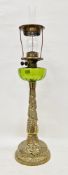 19th century oil lamp with a green glass well, the brass twisted tapered base with an embossed and