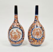Pair of Japanese imari bottle vases, 19th century, each painted with iron-red flower sprays and