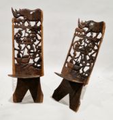 Two similar African Tribal hardwood birthing chairs, each being formed of two interlocking sections,