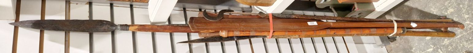 Three African spears, a pair of paddles and a reeded wooden flute cared with reeded ornament, all