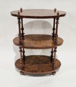 Victorian burr walnut oval whatnot, the three shaped half veneered shelves supported by turned