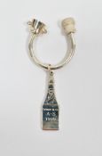 Tiffany & Co. silver key ring in the form of a champagne bottle hanging from a u-shaped bar, the