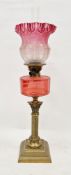 Victorian oil lamp, the cranberry tinted etched glass shade with frilled edge, with chimney,