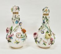 Pair of mid-19th century Derby porcelain flower-encrusted bottle vases and covers, red crowned D