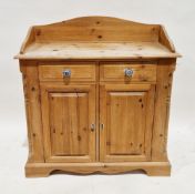 Pine side cabinet, the top with shaped upstand over two drawers having blue china handles and two