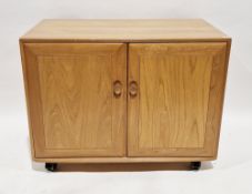 Ercol light elm Windsor media cabinet, the two doors opening to two pull-out shelves, 79cm high x