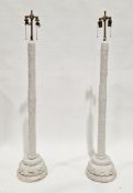 Pair of plaster standard lamps with brass double-branch light fittings, the column with moulded