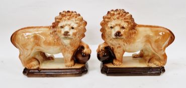 Pair of 20th century Boness style models of lions, each naturalistically modelled with a paw