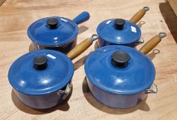 Three wooden handled blue glazed Le Creuset milk pans in sizes, 18cm, 16cm and 14cm and a similar