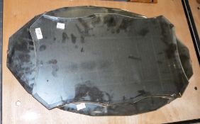 Two Art Deco bevelled glass wall mirrors, one of canted shield-shape and the other canted oval, 68.