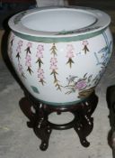 Contemporary Chinese-style fish bowl on wooden stand, decorated with famille rose style flowers