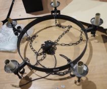 A contemporary black painted wrought iron five-light chandelier, suspended from chains, electrified,