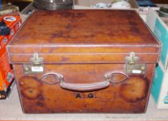 Vintage tan leather travelling case, with handle and brass fittings, initialled in black A.G. to the