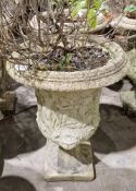 Two similar composite stone garden urns of campana form, each with moulded decoration of Roman
